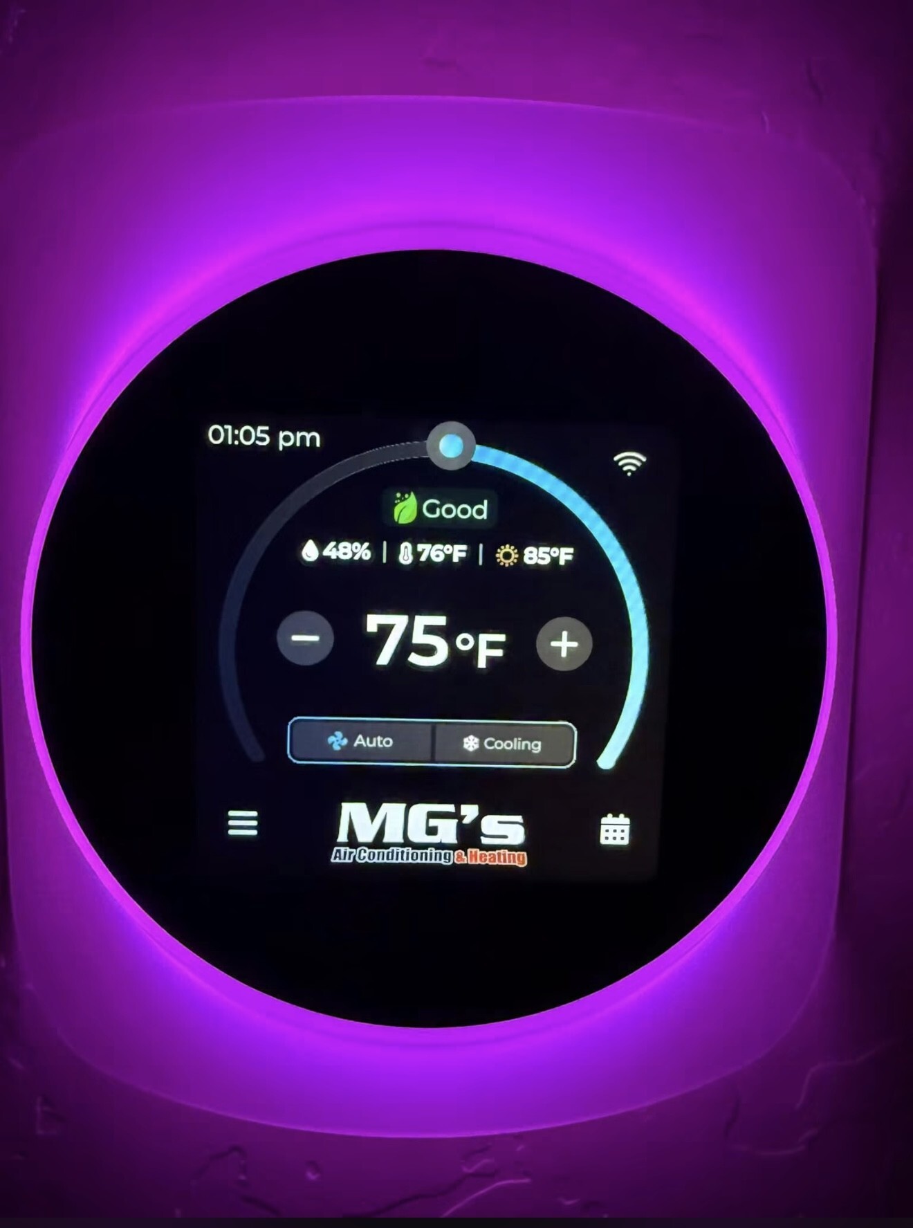 Smart thermostat installed and set up with the MG's brand on screen